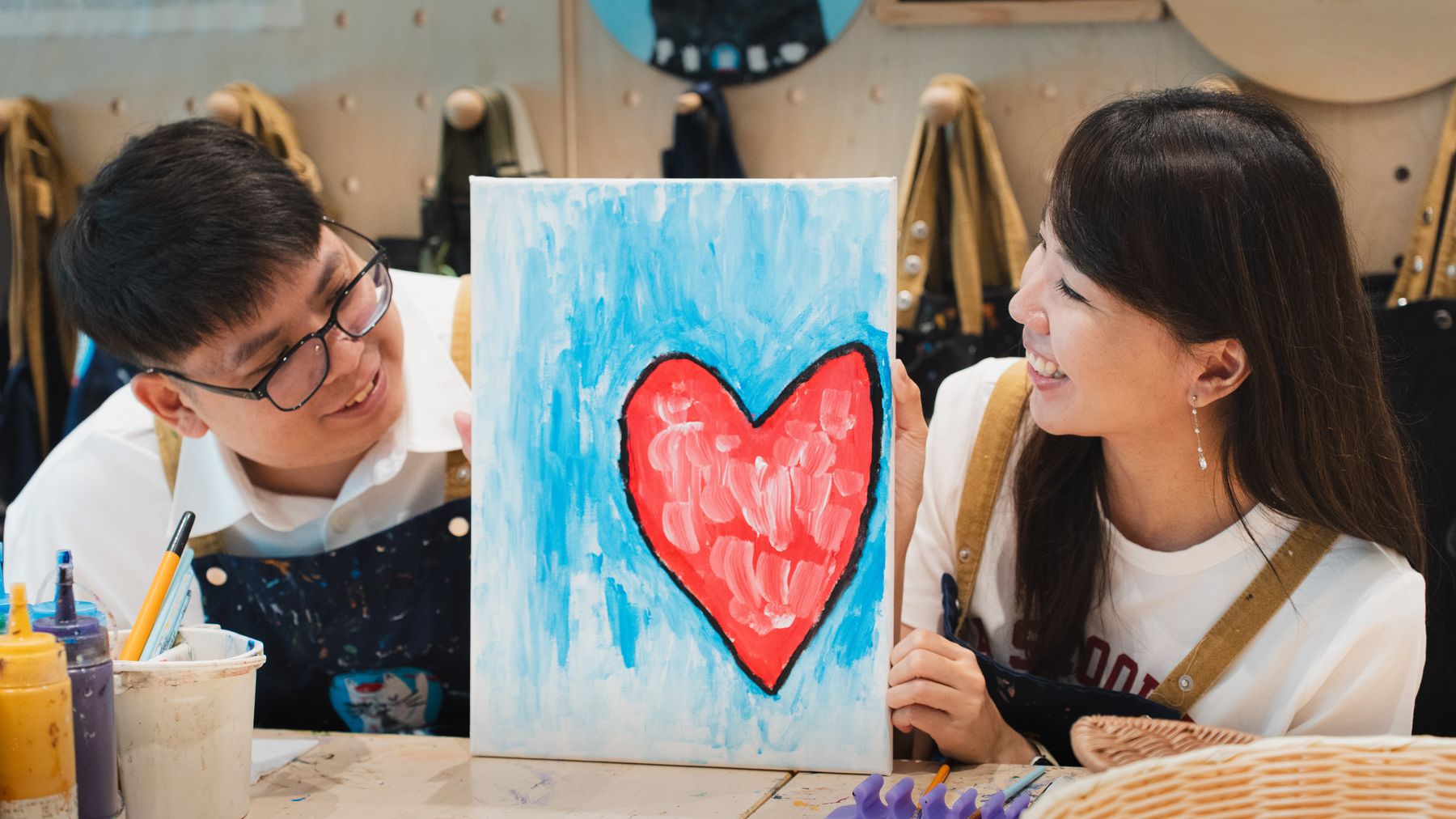 Couple gazing at each other over a finished painting